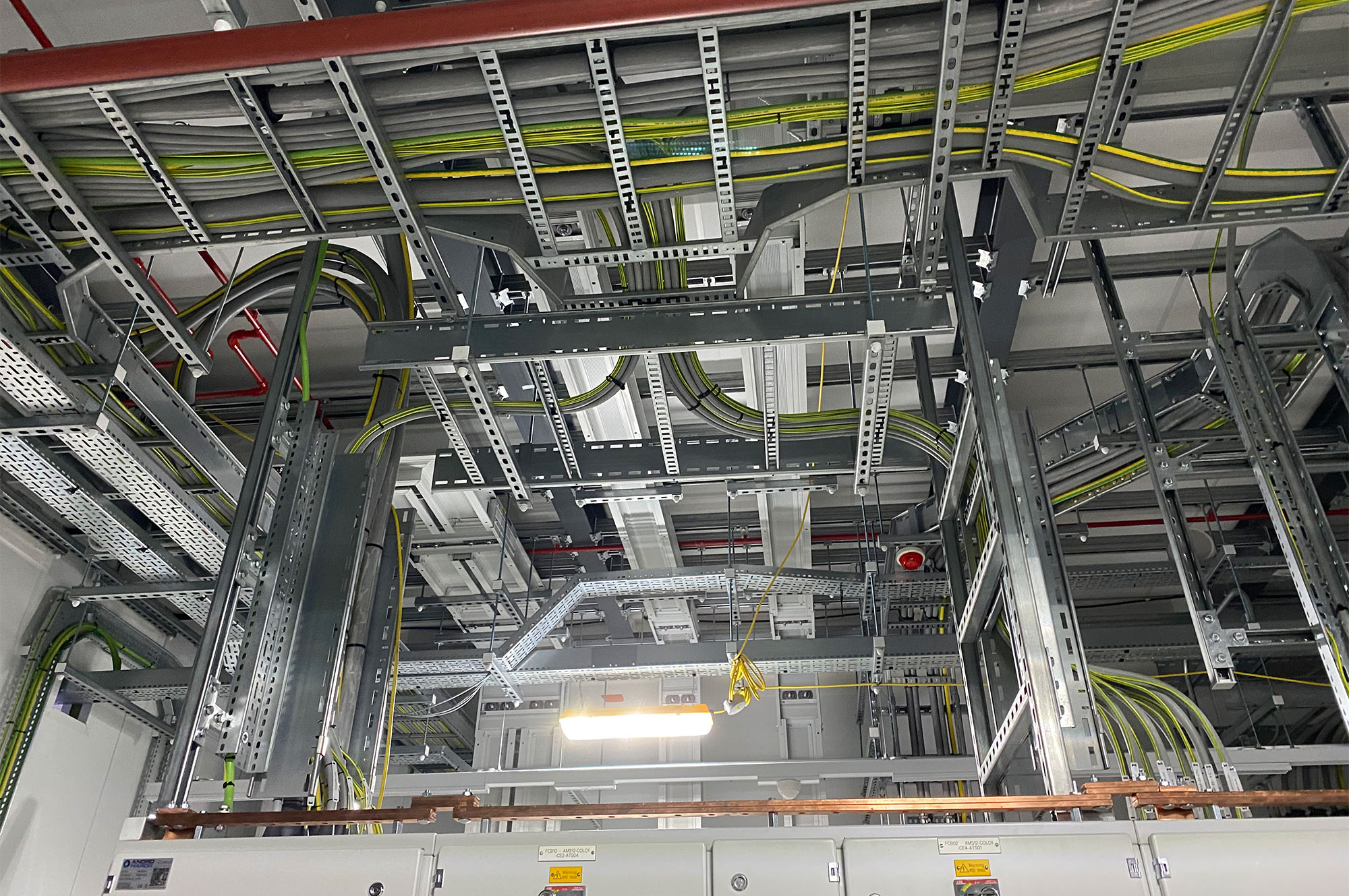 Komplexe Anordnung von Energiekabeln und Kabelkanälen in einer technischen Umgebung mit verschiedenen Leitungen und Montagestrukturen.