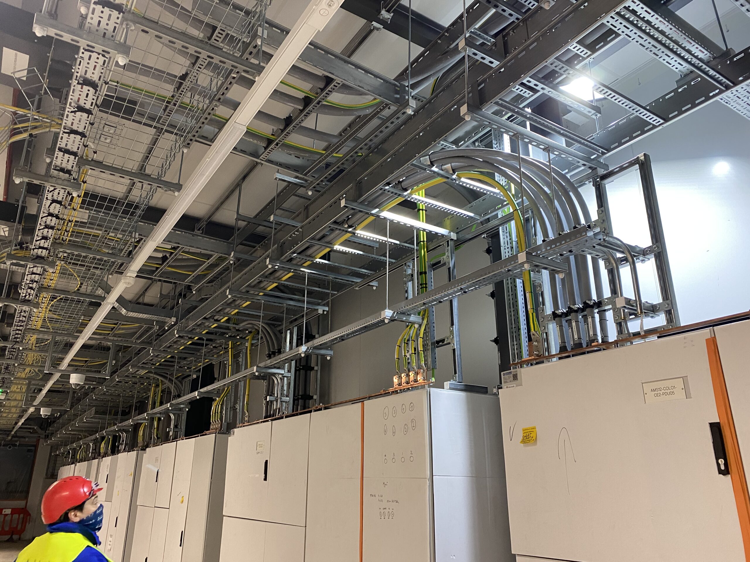 Technische Installation mit Kabelkanälen und Schaltschränken in einem modernen Gebäude. Sichtbare Verkabelung und elektrische Komponenten.