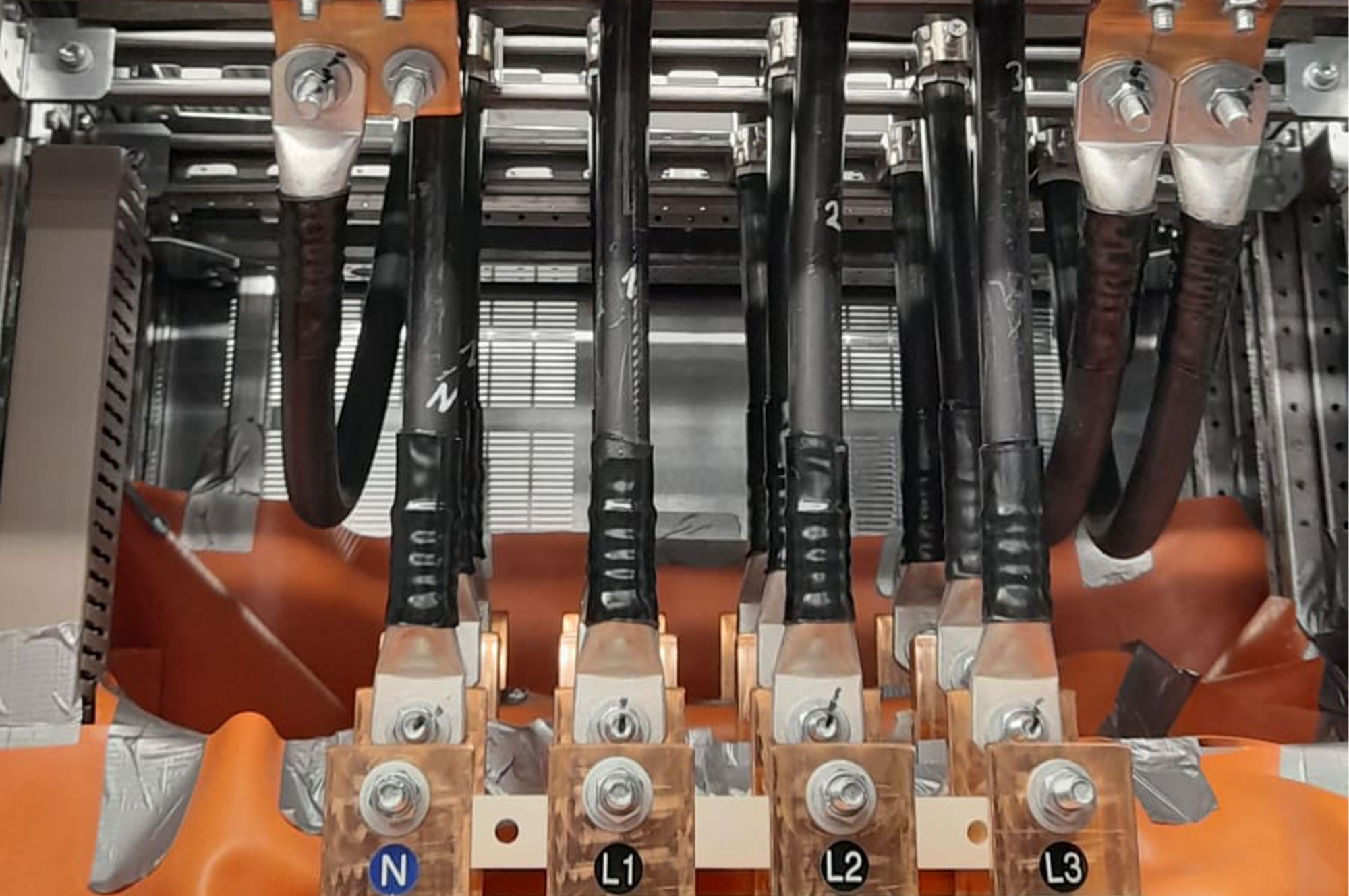 Verbundene Kabel und Anschlüsse in einem elektrischen Schaltschrank mit mehreren Leitungen und Befestigungselementen.