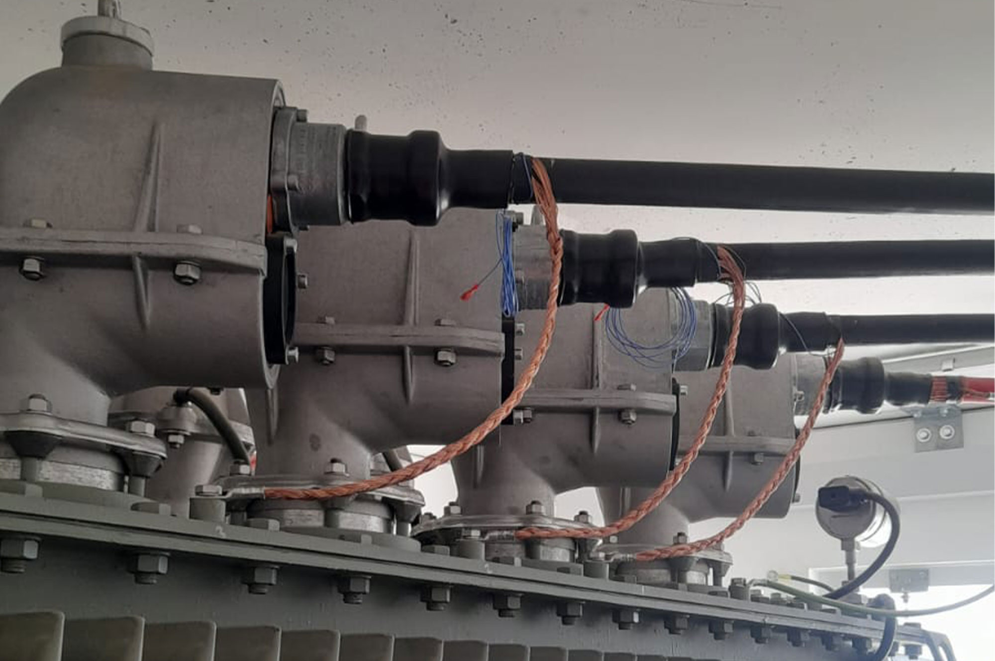 Drei Rohrleitungen mit Ventilen und elektrischen Anschlüssen in einem technischen Umfeld.